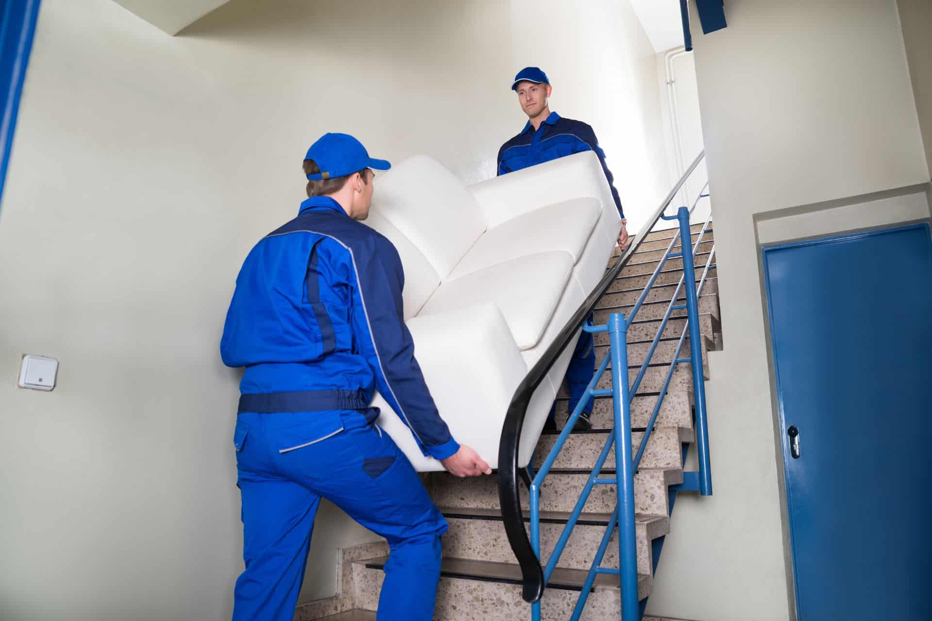 Two removalists moving out furniture through stairs